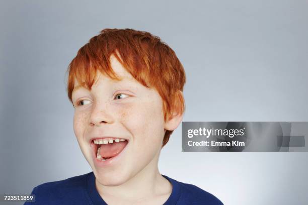 studio portrait of smiling red haired boy looking sideways - redhead boy fotografías e imágenes de stock