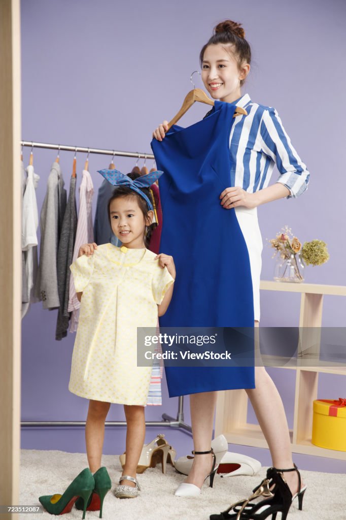 Young mother and child try on clothes
