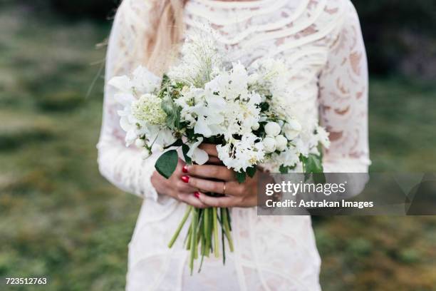 bride holding bouquet - wedding dress stock-fotos und bilder