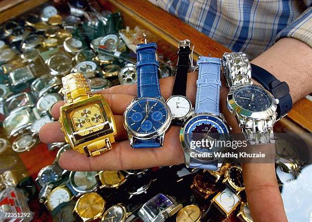 An Iraqi watch-seller shows his fake watches including Rolex which is about $15 November 5, 2004 in Baghdad, Iraq. Most of the goods sold on the...