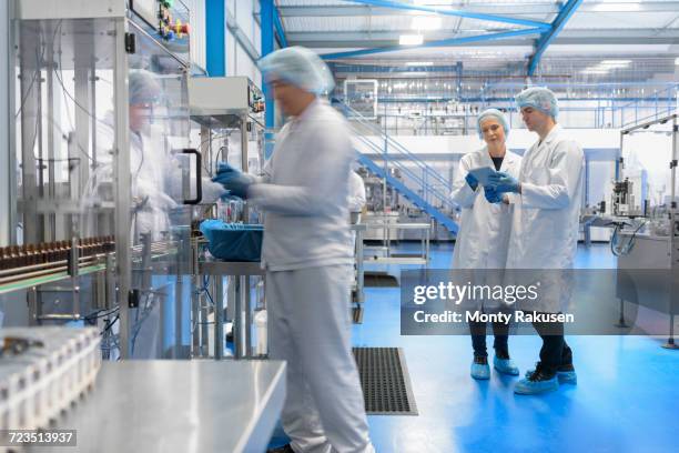 worker on packing line in pharmaceutical factory - laborkittel stock-fotos und bilder