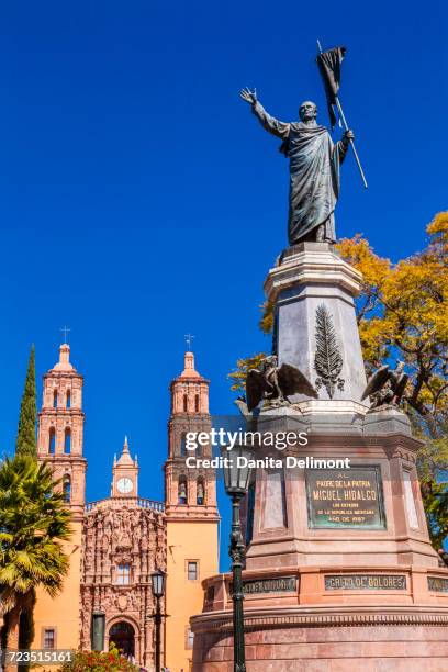 father miguel hidalgo statue, parroquia catedral in background, dolores hidalgo, mexico - dolores hidalgo stock-fotos und bilder