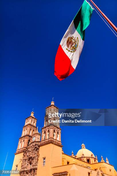 mexican flag and parroquia catedral, dolores hidalgo, mexico - dolores hidalgo stock-fotos und bilder