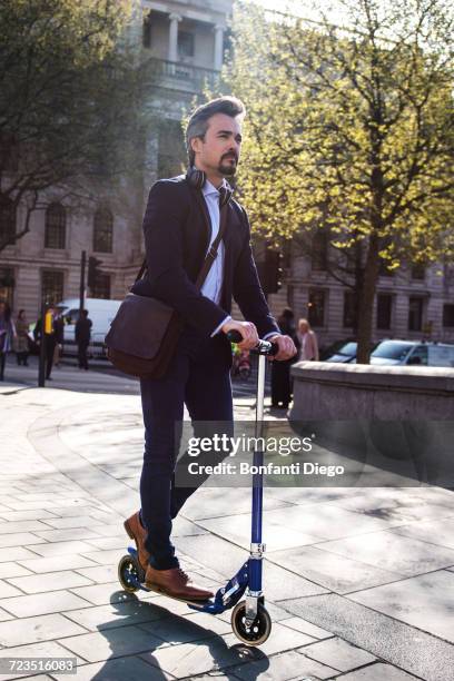 businessman on scooter, trafalgar square, london, uk - bruin pak stockfoto's en -beelden