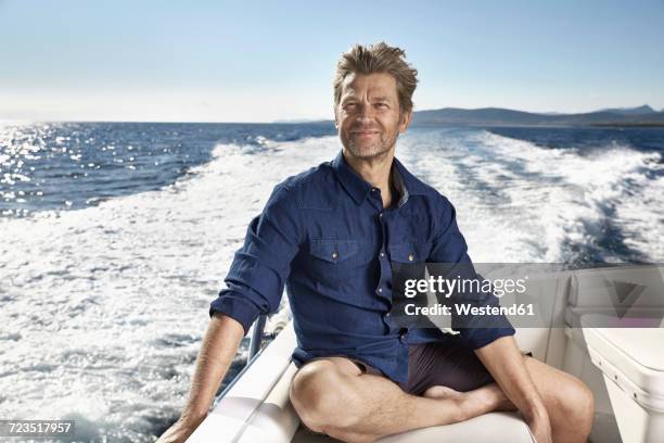 portrait of content mature man on his motor yacht - one mature man only foto e immagini stock