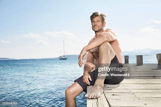 portrait of man sitting on jetty - human knee 個照片及圖片檔