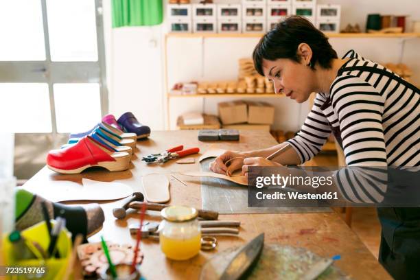 shoemaker working on template in her workshop - footwear manufacturing stock pictures, royalty-free photos & images