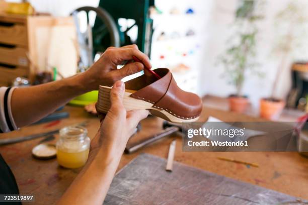 close-up of clogmaker working in her workshop - zuecos fotografías e imágenes de stock