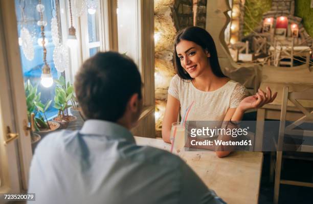 portrait of smiling young woman talking to her boyfriend in a restaurant - dating stock-fotos und bilder