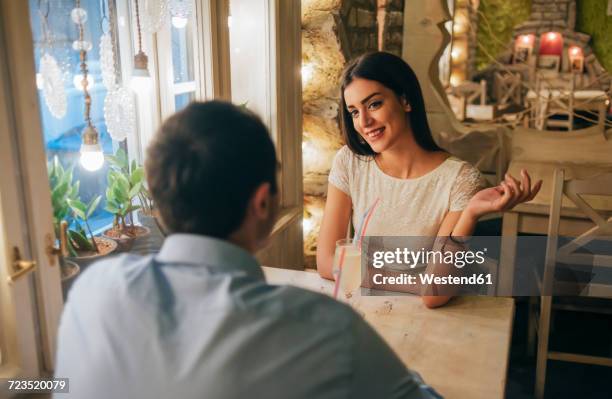 portrait of smiling young woman talking to her boyfriend in a restaurant - first date stockfoto's en -beelden