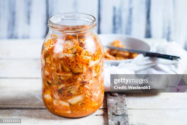 glass of homemade korean kimchi with chinese cabbage, scallions and carrots - kimchi stock-fotos und bilder