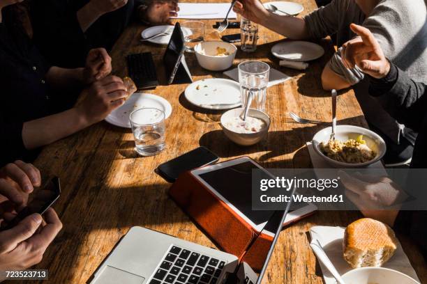 colleagues having lunch together in the office, partial view - conference dining table stockfoto's en -beelden