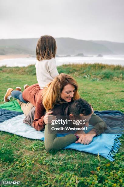 happy family on blanket at the coast - pile of blankets stock pictures, royalty-free photos & images