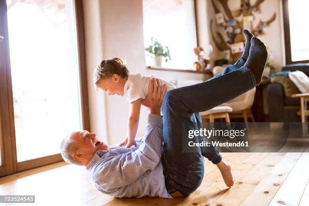 grandfather and grandson having fun at home - boys wrestling stockfoto's en -beelden