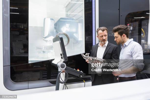two men in modern factory talking about a product - product innovation stock pictures, royalty-free photos & images