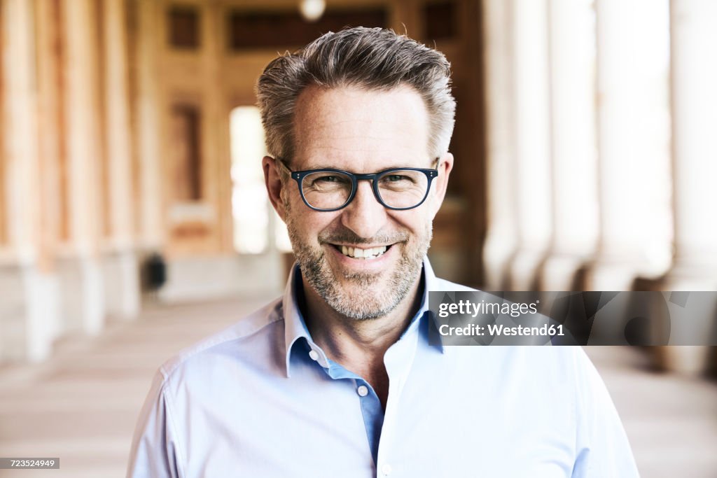 Portrait of smiling businessman with stubble wearing glasses