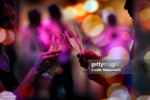 two guests on a party clinking champagne glasses - ereignis atmosphäre stock-fotos und bilder