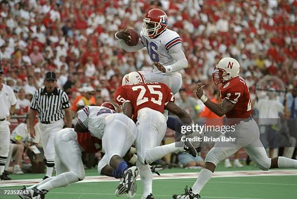 Troy Edwards of the Louisiana Tech Bulldogs is tackled in the air by Joe Walker of the Nebraska Cornhuskers during the Eddie Robinson Classic at Tom...