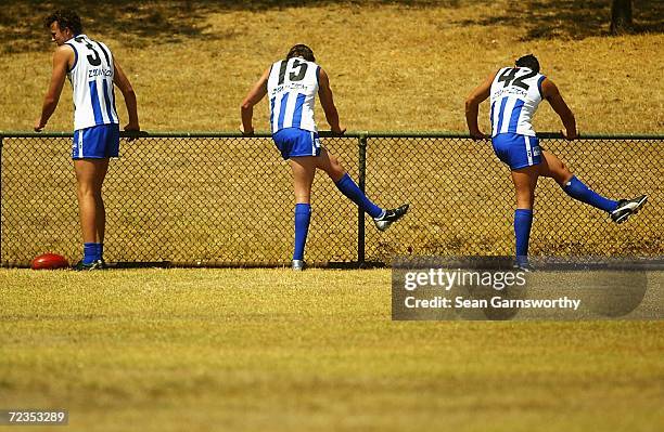 Kangaroos players David Hale, Kris Shore and Michael Firrito do stretching excerises during a Kangaroos training session in North Melbourne,...