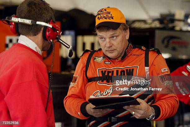 Jimmy Spencer driver of the Target Chip Ganassi Racing Dodge Intrepid R/T speaks to a crew member during Daytona 500 speedweeks in preparation for...