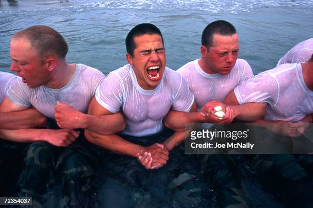Navy Seal trainees lock arms upon entering the frigid Pacific waters in this undated photo taken in 2000 at the Coronado Naval Amphibious Base in San...