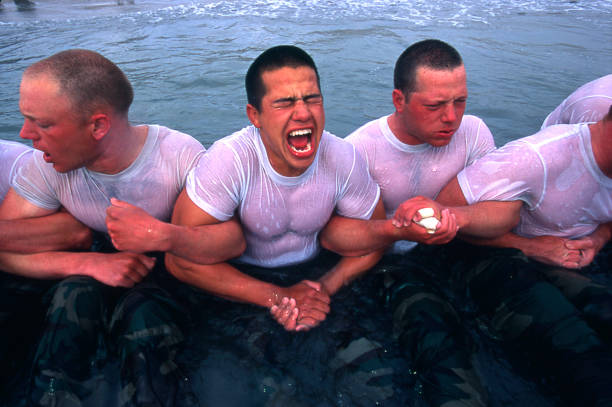 Navy Seal trainees lock arms upon entering the frigid Pacific waters in this undated photo taken in 2000 at the Coronado Naval Amphibious Base in San...