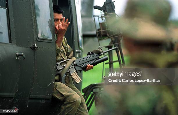 Guatemalan Army Soldier signals troops on the ground from a helicopter in El Quiche, some 100 miles North-West Guatemala City. January 17, 1996....