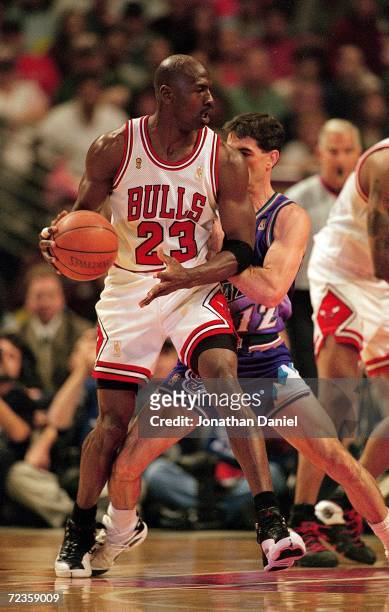 Michael Jordan of the Chicago Bulls dribbles the ball as he is guarded by John Stockton of the Utah Jazz during game six of the NBA Final at the...