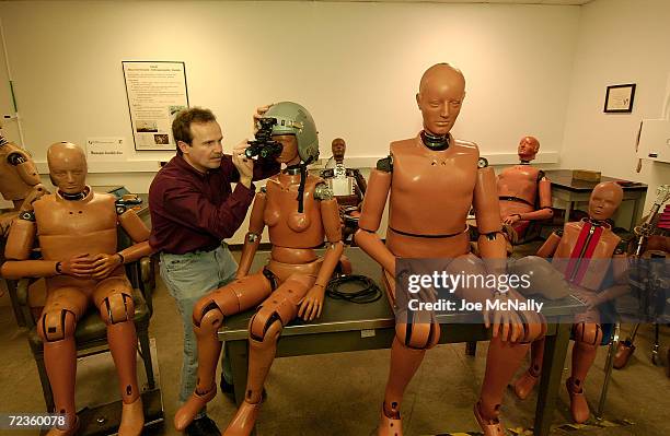 Designer Glenn Thomas works with test dummies Lois and Lard February 12, 2003 at Wright-Patterson Air Force Base in Dayton, Ohio. LOIS weighs in at...