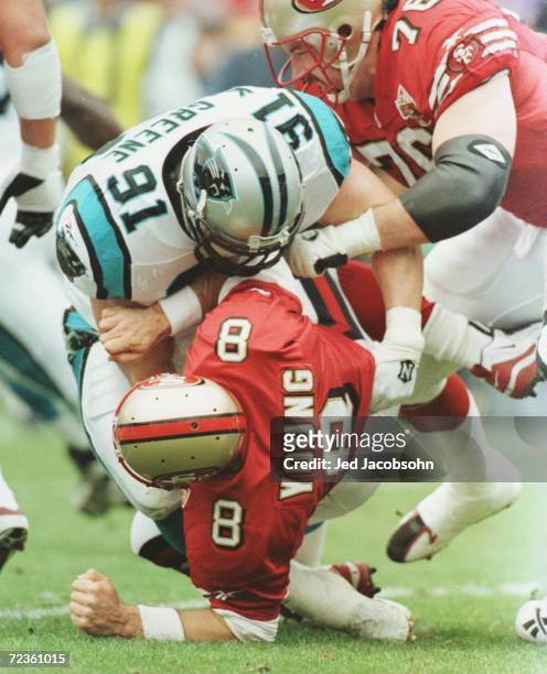 Kevin Greene of the Carolina Panthers hits quarterback Steve Young of the San Francisco 49ers after he threw the ball during the first half of their...