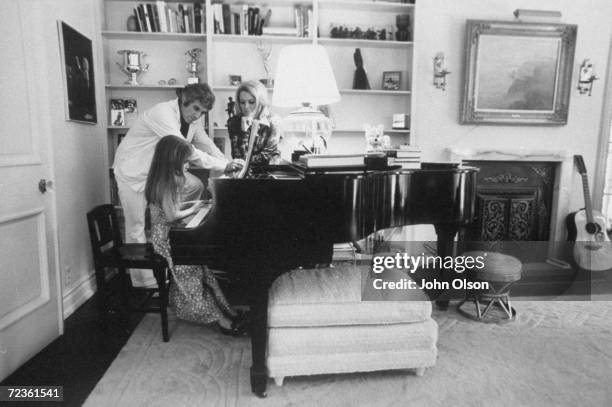 Composer Burt Bacharach Jr. And his actress wife Angie Dickinson watching their daughter play the piano.