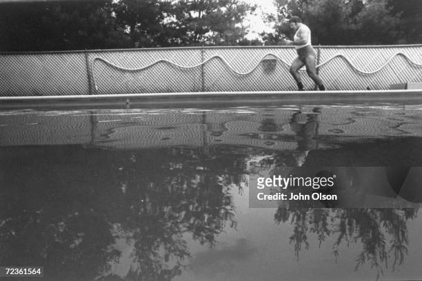 Championship wrestler Bruno Sammartino jogging around his pool as part of his daily exercise routine.