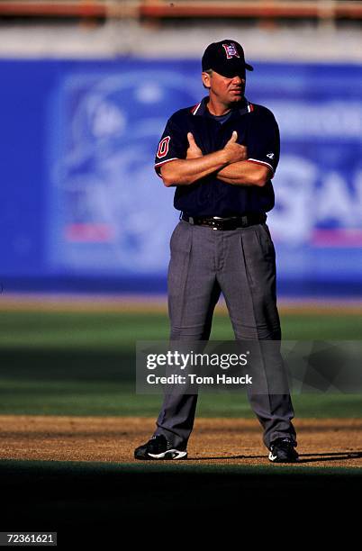 Umpire Tom Hallion stands on the field during a game between the Los Angeles Dodgers and the Milwaukee Brewers at Dodger Stadium in Los Angeles,...