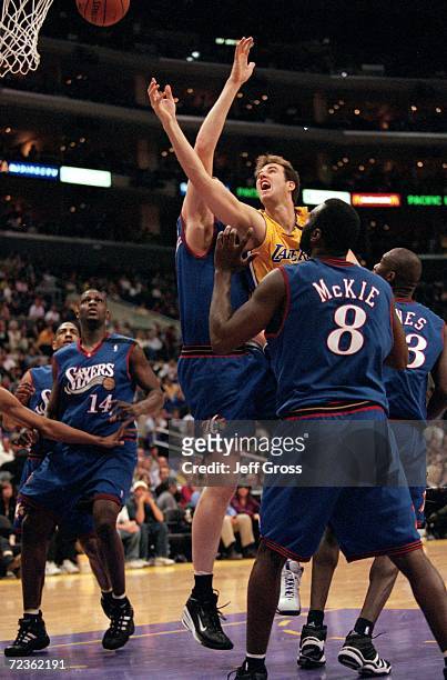 Travis Knight of the Los Angeles Lakers jumps and shoots the ball as Aaron McKie of the Philadelphia 76ers watches during the game at the Staples...