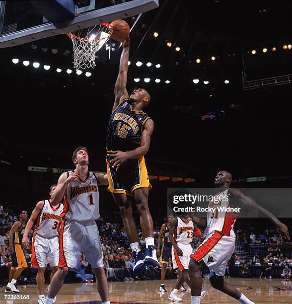 Guard Ron Artest of the Indiana Pacers dunks over forward Troy Murphy of the Golden State Warriors during the NBA game at the Arena in Oakland in...