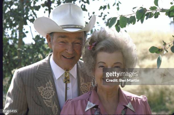 Actor Roy Rogers posing in dress cowboy outfit with his wife actress Dale Evans in her cowgirl outfit.