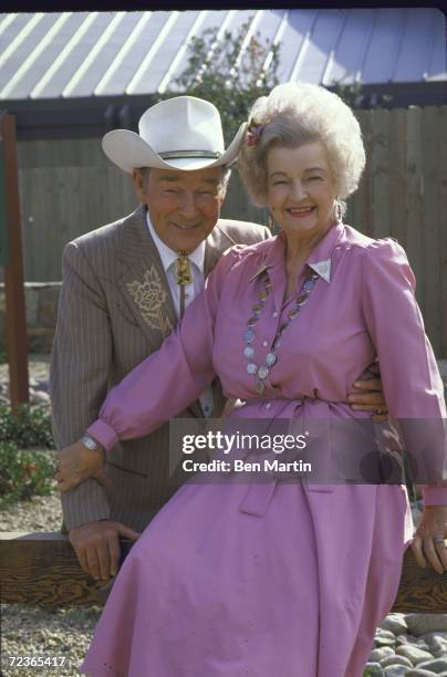 Actor Roy Rogers posing in dress cowboy outfit with his wife actress Dale Evans in her cowgirl outfit.