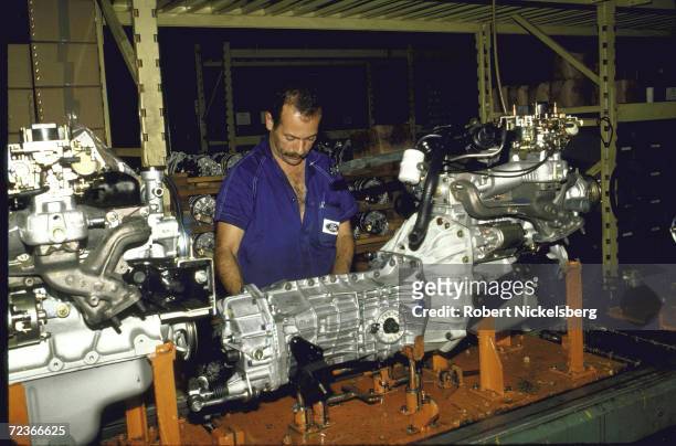 Worker wearing Ford logo adorned shirt, working on auto parts in Ford Motor plant , Sao Bernardo de Campo.