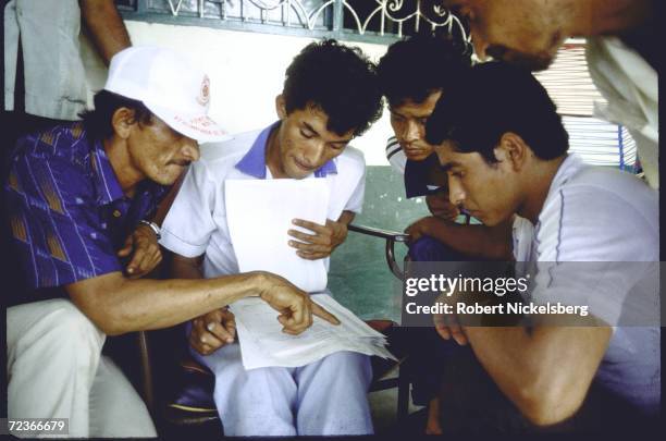 Scenes after eruption of Nevado del Ruiz & ensuing mudslide: aid workers going through survivor lists.