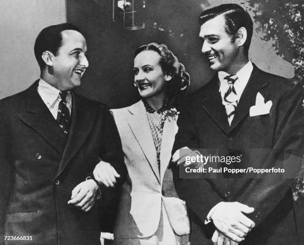 American film actress Carole Lombard poses with her husband Clark Gable right and Gable's press agent Otto Winkler in Los Angeles circa 1941. Both...