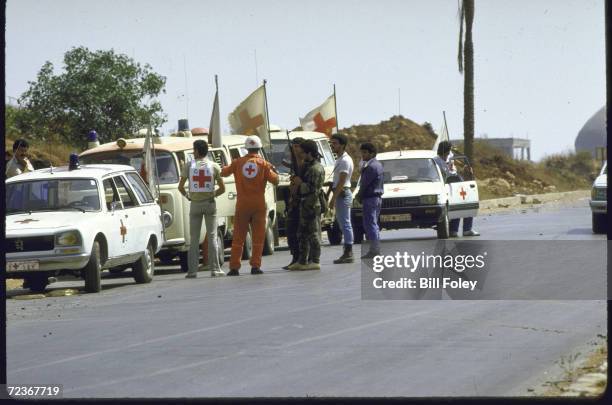 Shiite Amal militiamen with Red Cross workers and ambulances outside Burj Al Brajneh Palestinian refugee camp where Red Cross seeks entry to care for...