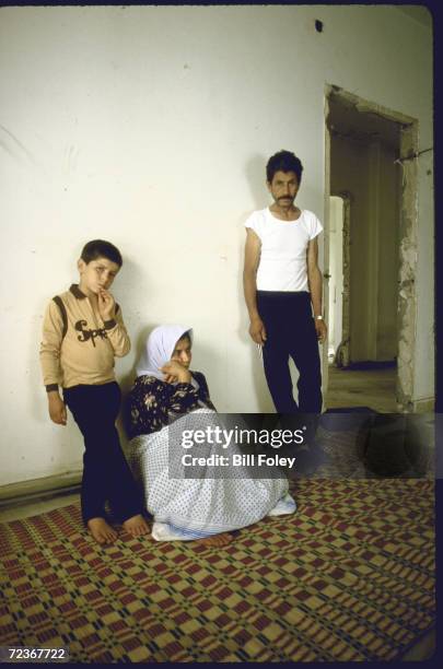 Family of 3, refugees from fighting in camps, posing in their new home amid wreckage at old US Embassy, car bombed in 4/83, on Corniche.