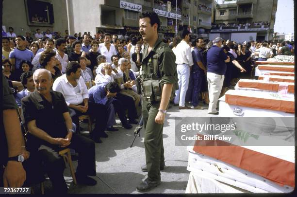 Christian Lebanese militiamen providing security during mass funeral for victims of car bombing.