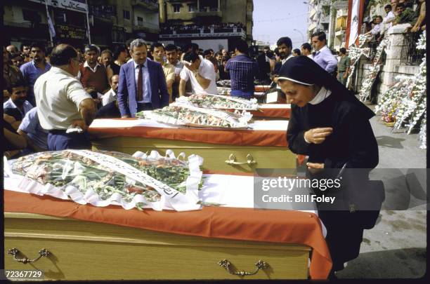 Mourners, including Maronite Nun, at Christian mass funeral for car bombing victims.
