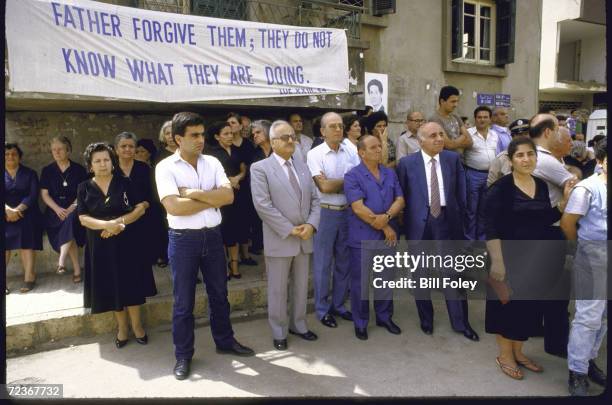 Christians mourning during mass funeral for victims of car bombing, with picture of President Amin Gemayel in rear.