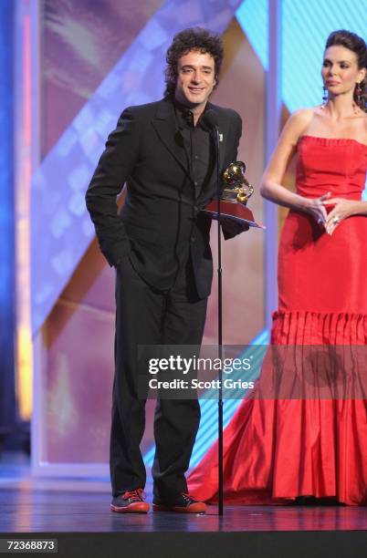 Gustavo Cerati accepts his award for "Best Rock Solo Vocal Album" from presenter Barbara Palacios on stage at the 7th Annual Latin Grammy Awards at...
