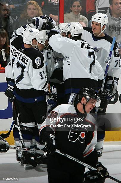 Tim Taylor of the Tampa Bay Lightning is mobbed by team mates after scoring a goal while Mike Richards of the Philadelphia Flyers skates by November...