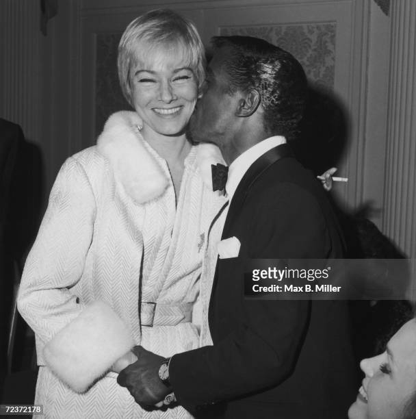 American singer and actor Sammy Davis Jr. Kisses his wife, Swedish actress May Britt, at a dinner held in his honour at the Friar's Club, New York...
