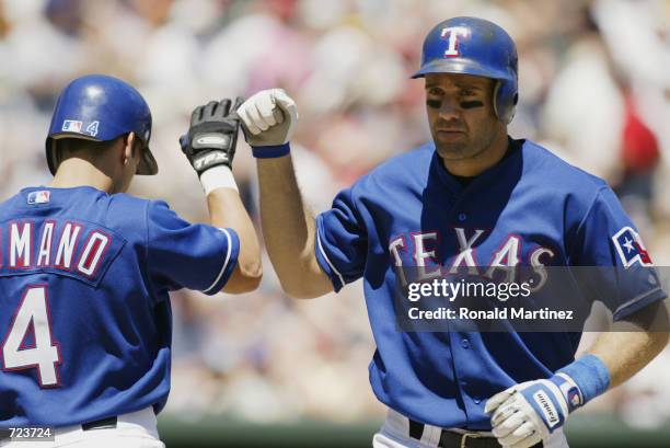 Bill Haselman and Jason Ramano both of the Texas Rangers celebrate during the game against the Kansas City Royals at The Ballpark in Arlington, Texas...