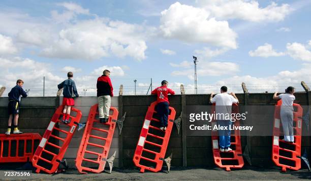 Liverpool fans use roadworks barriers to get a glimpse of the Liverpool team training session ahead of the Champions League Semi Final Second Leg...